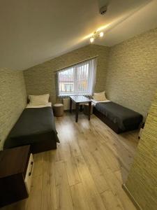 Habitación con 2 camas, escritorio y ventana. en Ні пуху, ні пера!, en Reshetylivka