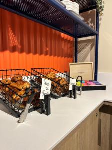 un comptoir de boulangerie avec des raquettes de pâtisseries exposées dans l'établissement ibis budget Loudéac Vélodrome, à Loudéac