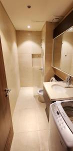 uma casa de banho com um chuveiro, um lavatório e um WC. em Tambuli Seaside Resort Residences em Lapu Lapu City