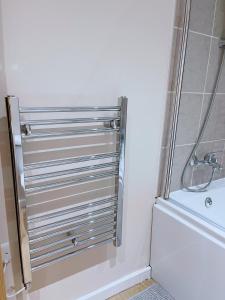 uma porta de chuveiro numa casa de banho com banheira em GALAXY APARTMENT em Stockport