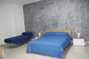 - une chambre avec un lit bleu et deux chaises dans l'établissement AFFITTACAMERE MONTE OLIMPO, à Galatone