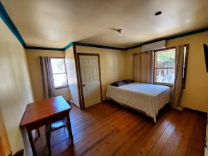 a bedroom with a bed and a table and a desk at Hotel Caribbean Inn in West End