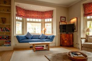 a living room with a blue couch and a tv at Sunbeam, familievilla in Knokke-Zoute in Knokke-Heist