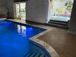 a swimming pool with blue lights in a house at Les Hôtes de Sermaize in Bois-le-Roi