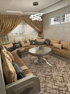 ein Wohnzimmer mit einem Sofa und einem Tisch in der Unterkunft Villa famillial avec piscine Founty in Agadir