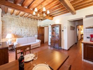 a living room with a couch and a table with wine glasses at Castello di Fulignano Soarzio panoramic apartment in San Gimignano