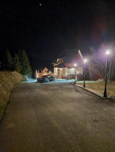 una casa con un estacionamiento por la noche en Vila Rajski kutak Kopaonik, en Kopaonik