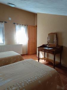 a bedroom with two beds and a mirror and a desk at FUENTE GRANDE II in Muñoveros +1 photo