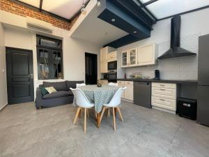 a kitchen and living room with a table and chairs at Le Secret d'Agathe in Amiens