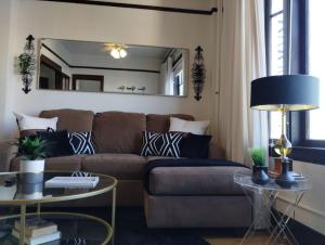 sala de estar con sofá marrón y espejo en Studio for 2- Queen Mary, Ocean, and City View, en Long Beach