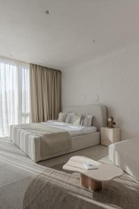 a white bedroom with a large bed and a window at Sfumato Rooms in Odesa