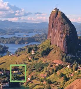 Una montaña con una casa encima en Hermosa casa de campo en GUATAPÉ, en Guatapé