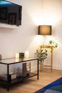 un soggiorno con tavolo, TV e lampada di Luxury Apartment In The Prime Hollywood Location a Los Angeles