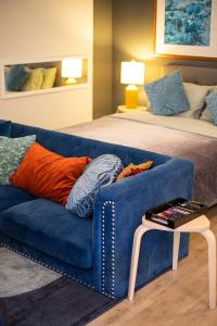 ein Wohnzimmer mit einem blauen Sofa und einem Bett in der Unterkunft Luxury Apartment In The Prime Hollywood Location in Los Angeles