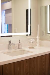 a bathroom with a white sink and a mirror at Luxury Apartment In The Prime Hollywood Location in Los Angeles