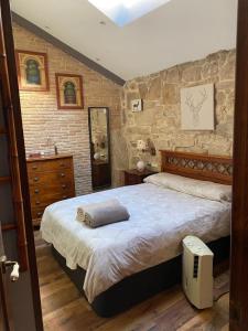 a bedroom with a large bed and a stone wall at Casa Celsa cerca del mar in Baiona