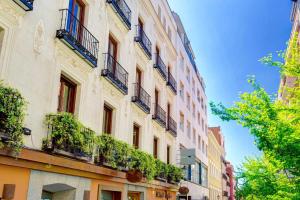 een hoog gebouw met ramen en balkons aan een straat bij Luxury duplex close to Gran Via Colon in Madrid