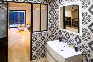 a bathroom with a black and white patterned wall at Magnifique appartement au centre-ville de Nice in Nice