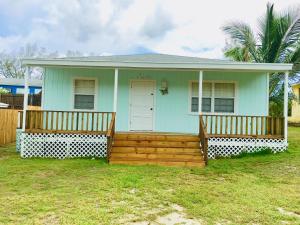 a small blue house with two wooden decks at Bimini Seaside Villas - Green Cottage with Bay/Marina View in Alice Town