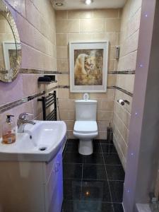 a bathroom with a white toilet and a sink at Entire Spacious 4 Bedroom Zen House with Garden View in Bromley