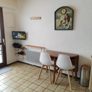 comedor con mesa y 2 sillas blancas en Studio le Dahut en Champagny-en-Vanoise