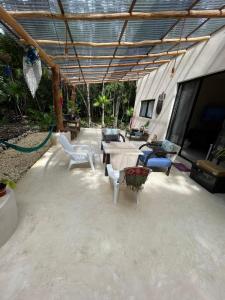 a patio with chairs and tables and a tent at Keiki House in Akumal