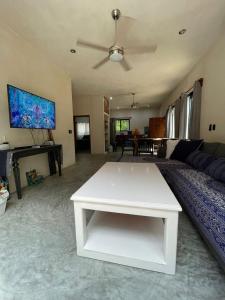 ein Wohnzimmer mit einem Sofa und einem weißen Tisch in der Unterkunft Keiki House in Akumal