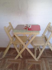 una mesa de picnic con dos sillas y una caja roja. en Apartamento Atlantida, en Villa Argentina