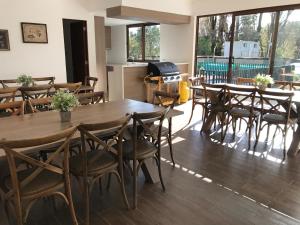 une salle à manger avec des tables et des chaises en bois dans l'établissement Casa ITALIA 2 Condominio Parque Pinares, à Pucón