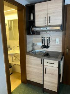 małą kuchnię z umywalką i łazienką w obiekcie Altes Holzhaus w Solden