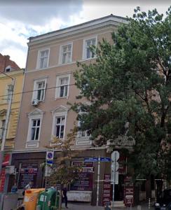 un grand bâtiment rose sur le côté d'une rue dans l'établissement NEW High-End 2BR Apartment with Parking, à Sofia