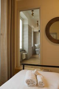 a bedroom with a mirror and a bed with towels at Piccolo Borgo in Chiavari