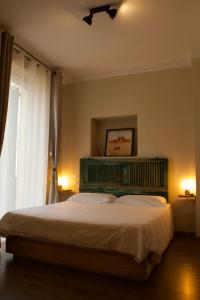 1 dormitorio con 1 cama con cabecero verde y ventana en Piccolo Borgo en Chiavari