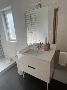 a white bathroom with a sink and a mirror at Quinta da Portelada in Peso da Régua