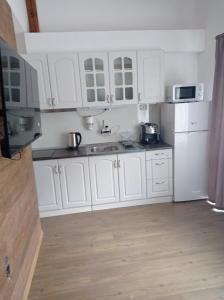 uma cozinha branca com armários brancos e electrodomésticos brancos em Apartment Kirili and Metodi 41 - 8 С em Berkovitsa
