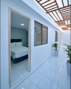 - une chambre avec un lit et une grande fenêtre dans l'établissement Casa Encanto Manga, à Carthagène des Indes