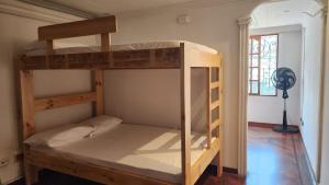 a bunk bed in a room with a fan at Paisa Hostel Medellín in Medellín