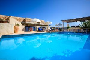 a large swimming pool with blue water at Kalimera Village in Hersonissos