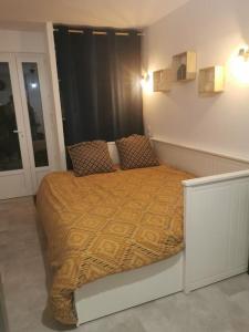 ein Schlafzimmer mit einem Bett mit einer Orangendecke darauf in der Unterkunft Ôcalme, Idéal à 2, jardin, plage in Bréhal