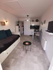 un salon avec un canapé et une table dans l'établissement Ôcalme, Idéal à 2, jardin, plage, à Bréhal