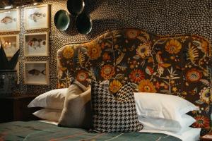 a bedroom with a bed with a floral patterned wall at Knus Richmond in Richmond