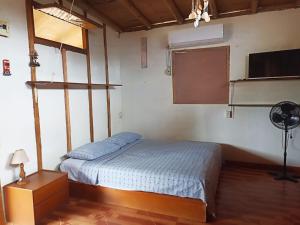 a bedroom with a bed and a flat screen tv at La Casa de Diego in Zorritos