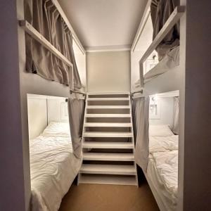 a room with two bunk beds and a staircase at نجد هاوس - نساء فقط Ladies Hostel in Riyadh