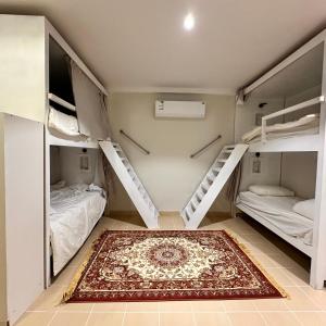 a room with two bunk beds and a rug at نجد هاوس - نساء فقط Ladies Hostel in Riyadh