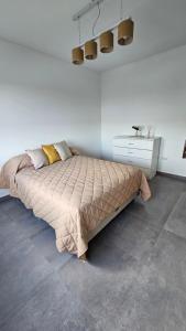 a bedroom with a bed and a white dresser at Departamento Villarino in Puerto Madryn