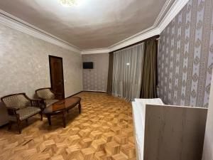 a room with a couch and a table and a chair at Baron Hotel in Vanadzor