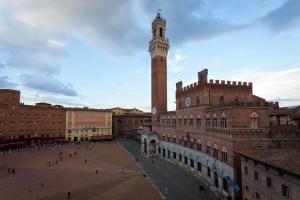 una città con una torre dell'orologio alta e un edificio di Palazzo Giorgi a Siena