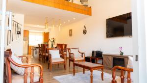 a living room with a table and chairs and a television at Sweet Home Departamento in Loja