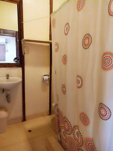 a bathroom with a shower curtain and a sink at La Casa de Diego in Zorritos