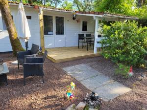 une maison dotée d'une terrasse en bois avec une table et des chaises dans l'établissement Chalet-dordogne B10 camping Château Le Verdoyer - Champs Romain, Dordogne, à Puyhardy